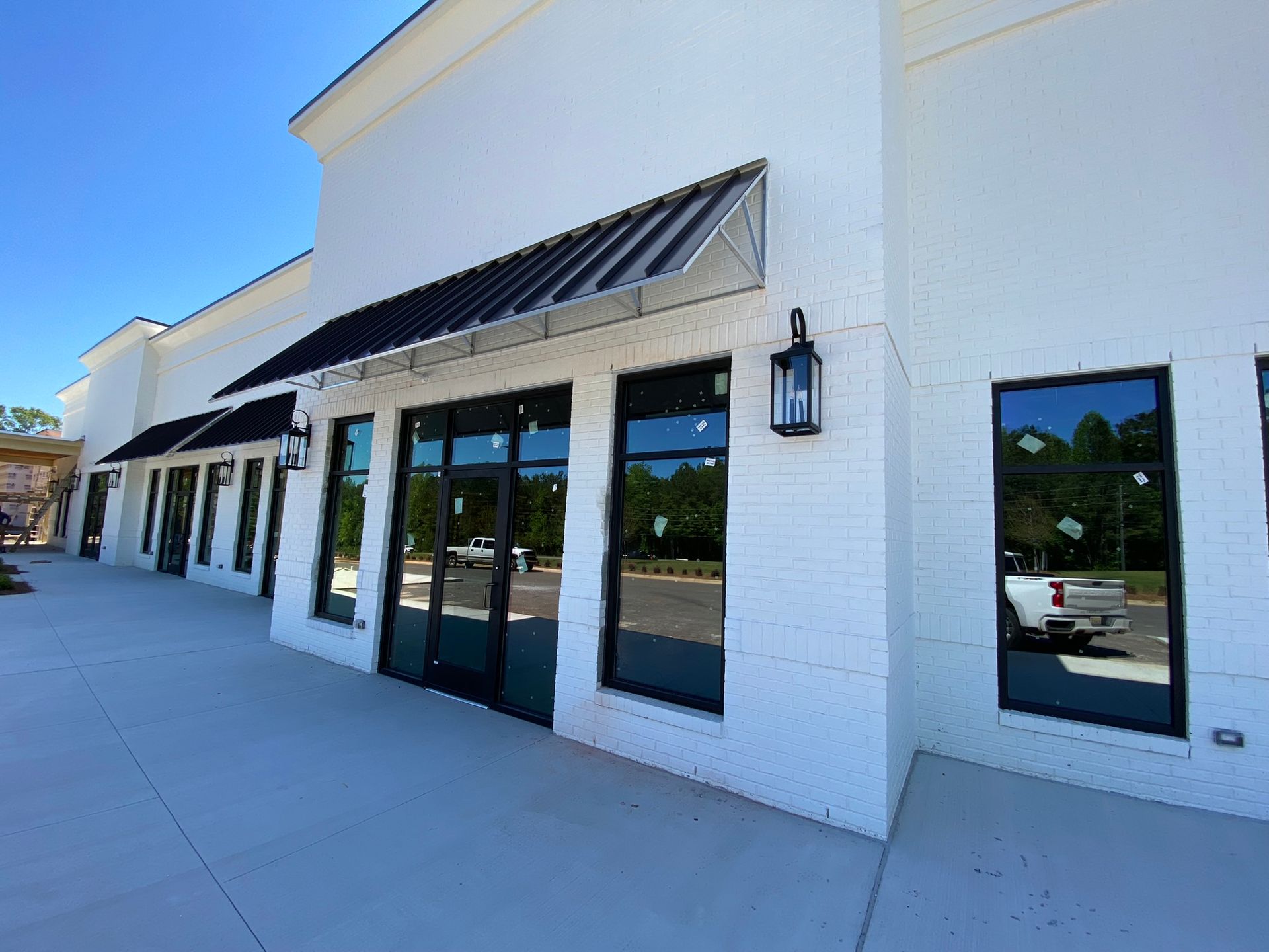 A white building with a lot of windows and a black awning.