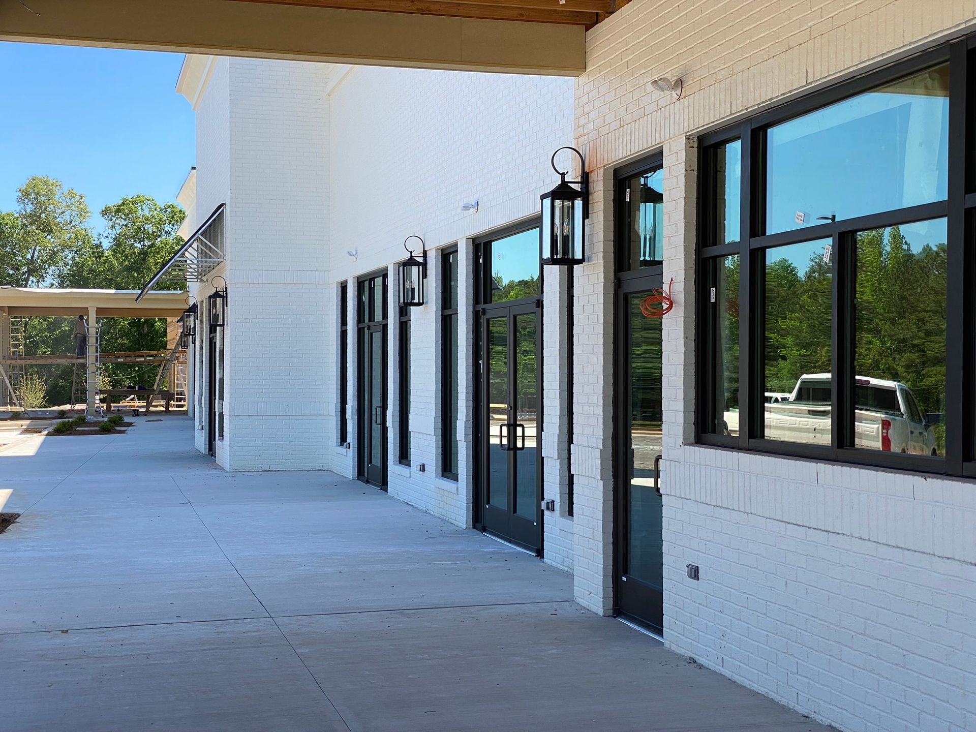 A row of white brick buildings with black windows and doors.