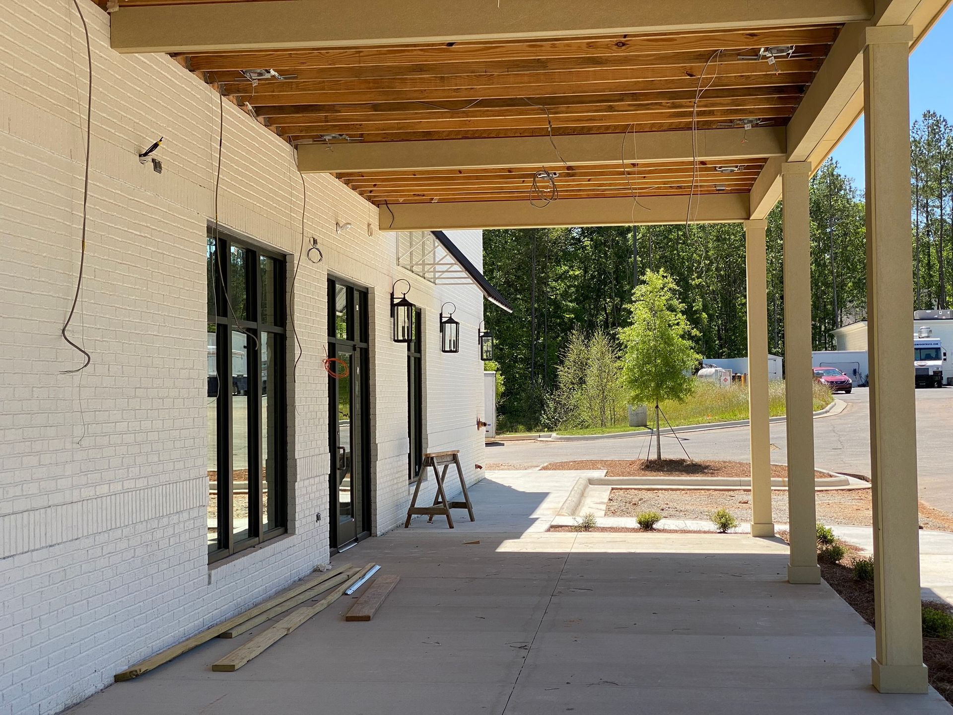 A white brick building with a wooden covered porch.