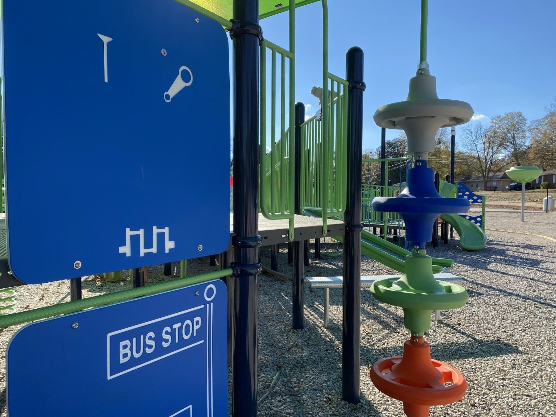A playground with a blue sign that says bus stop