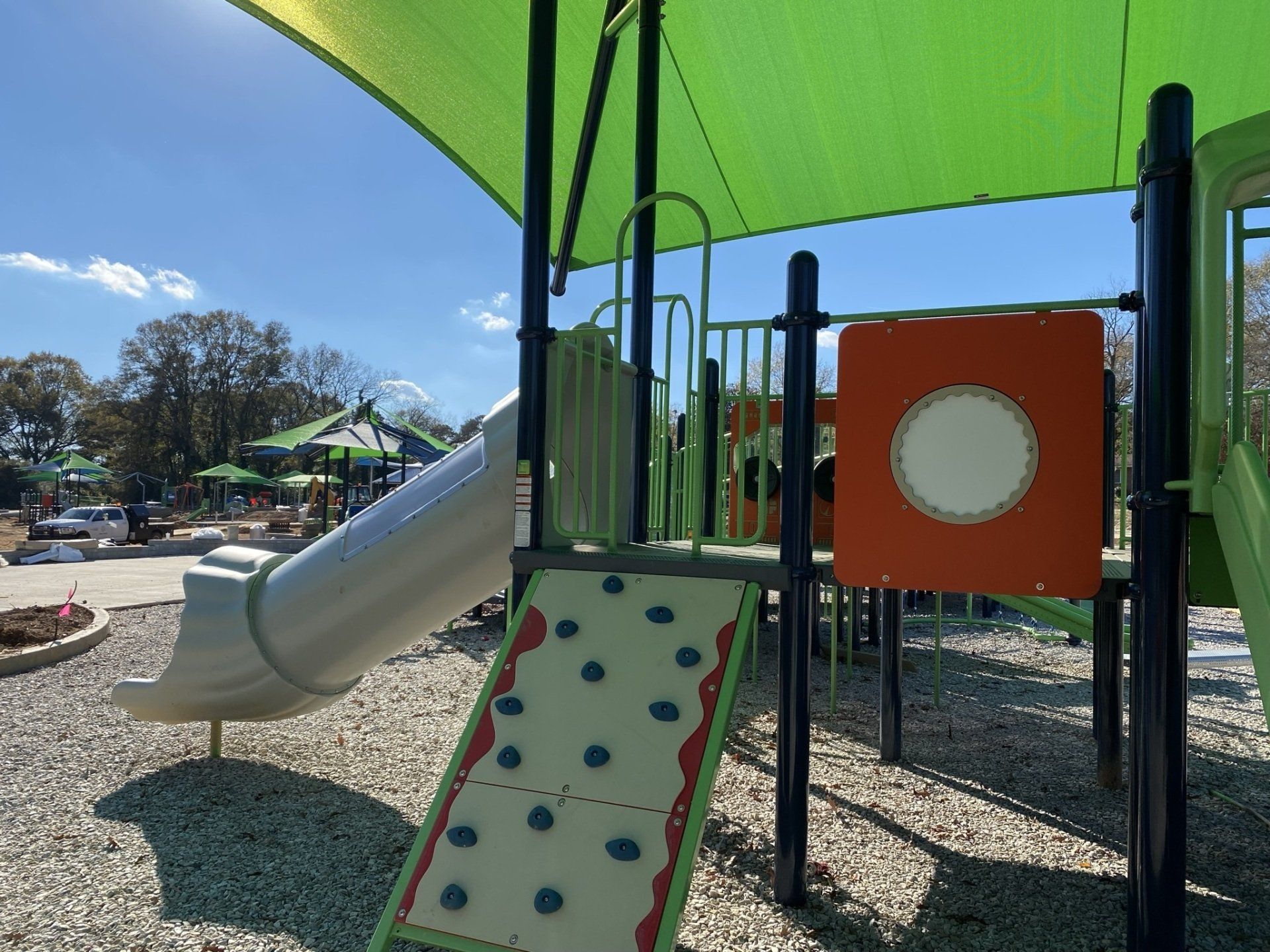 A playground with a slide and a climbing wall.