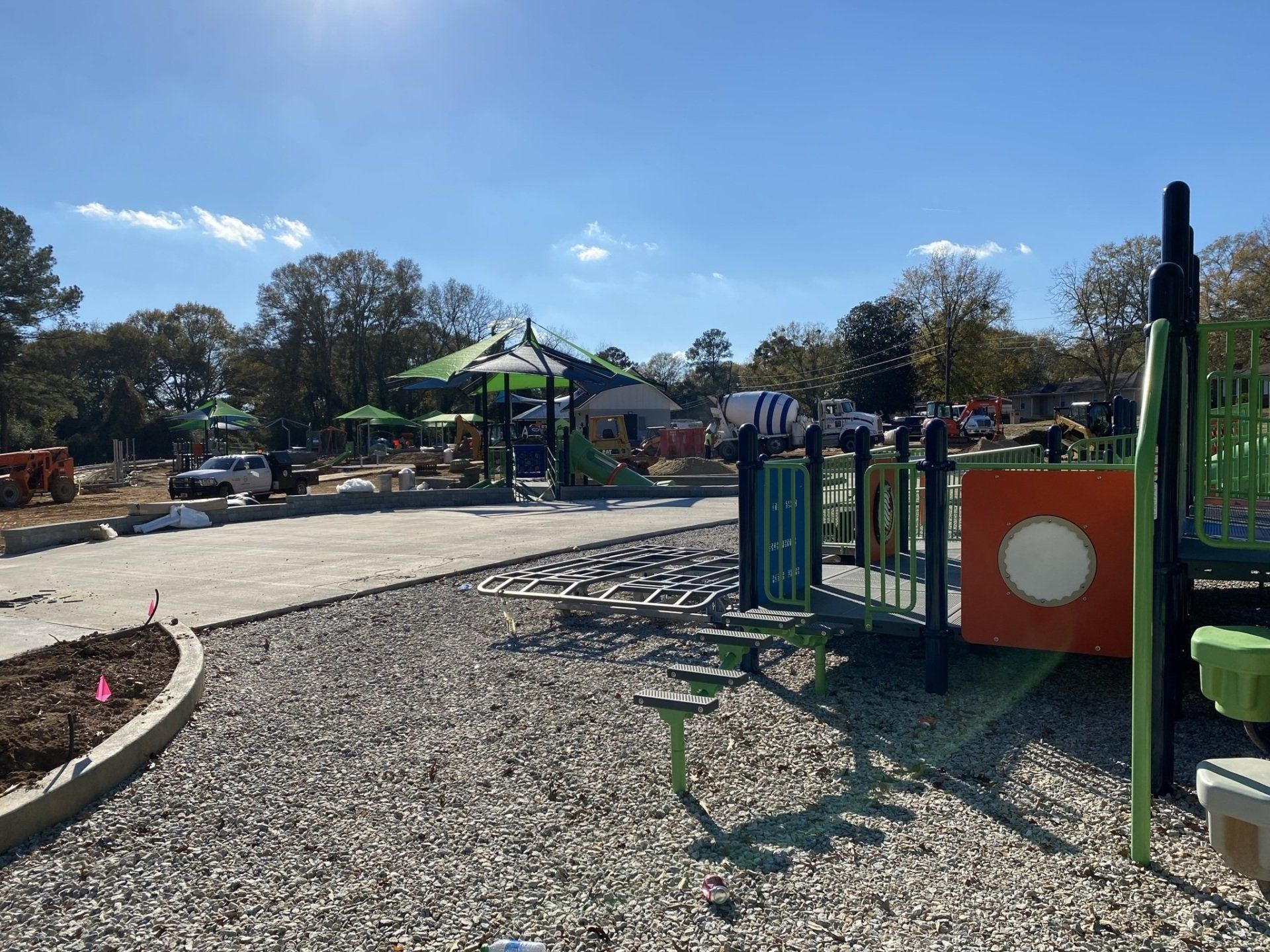A playground is being built in a park on a sunny day.