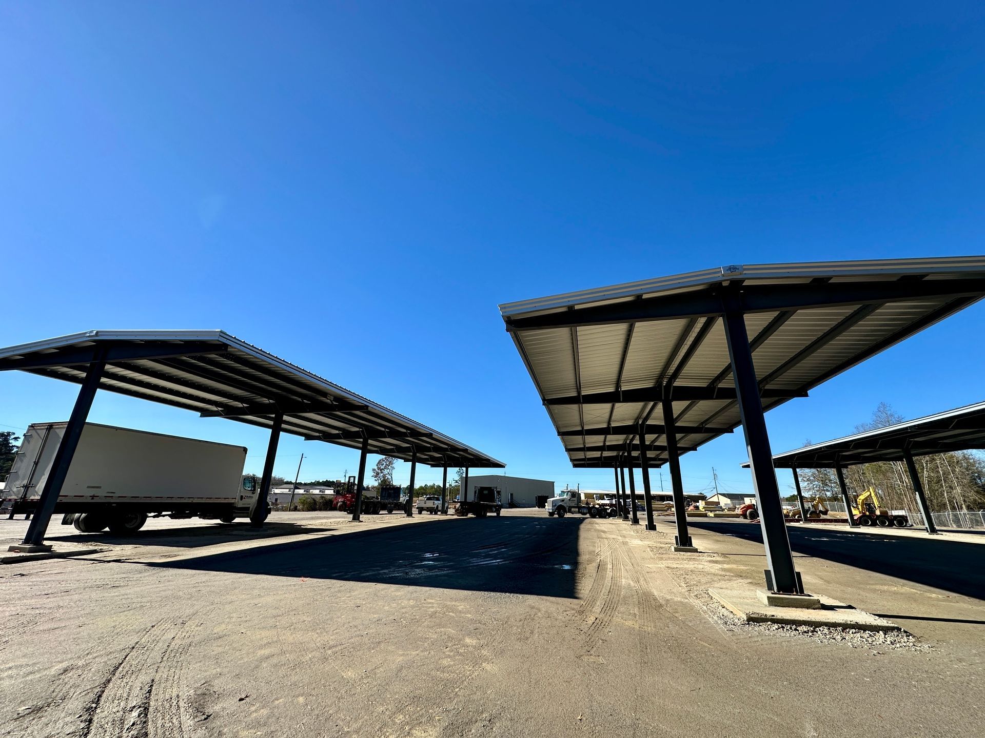 An aerial view of a new Hovey Precast office building with a blue roof surrounded by trees.