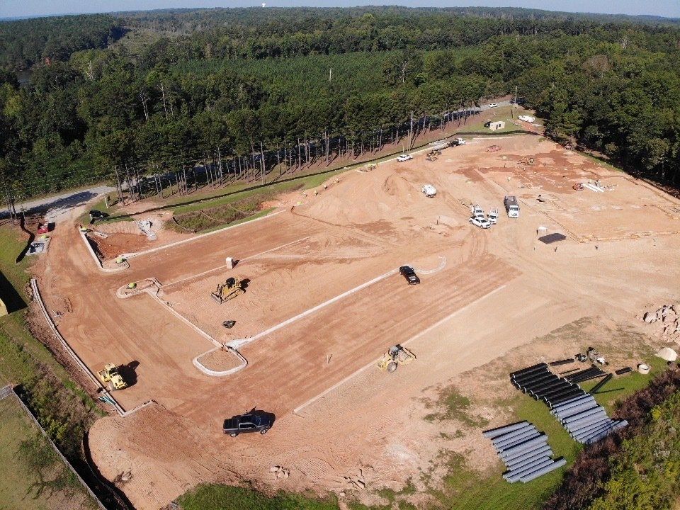 An aerial view of a warehouse under construction in the middle of a forest.