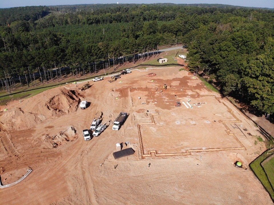 An aerial view of a construction site in the middle of a forest.