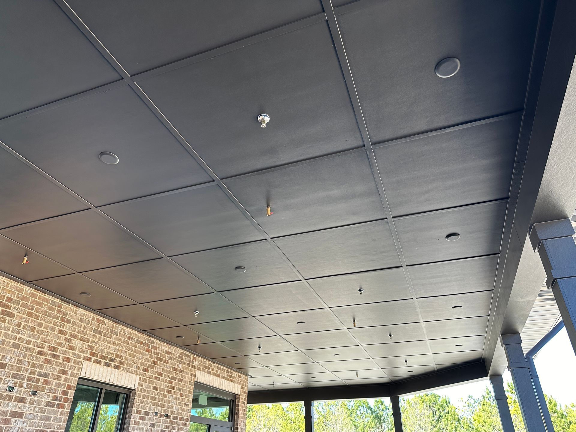 The ceiling of a building with a brick wall and a black ceiling.