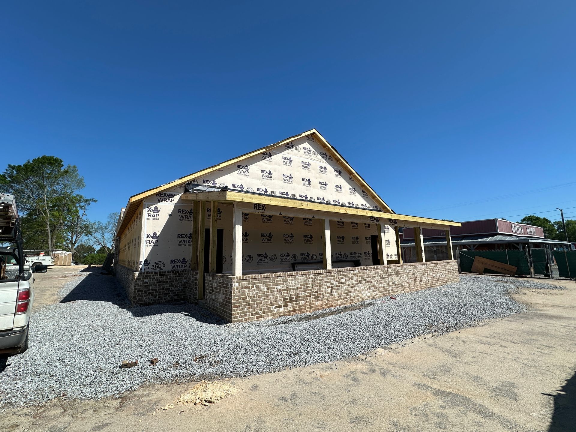 A truck is parked in front of a building under construction.