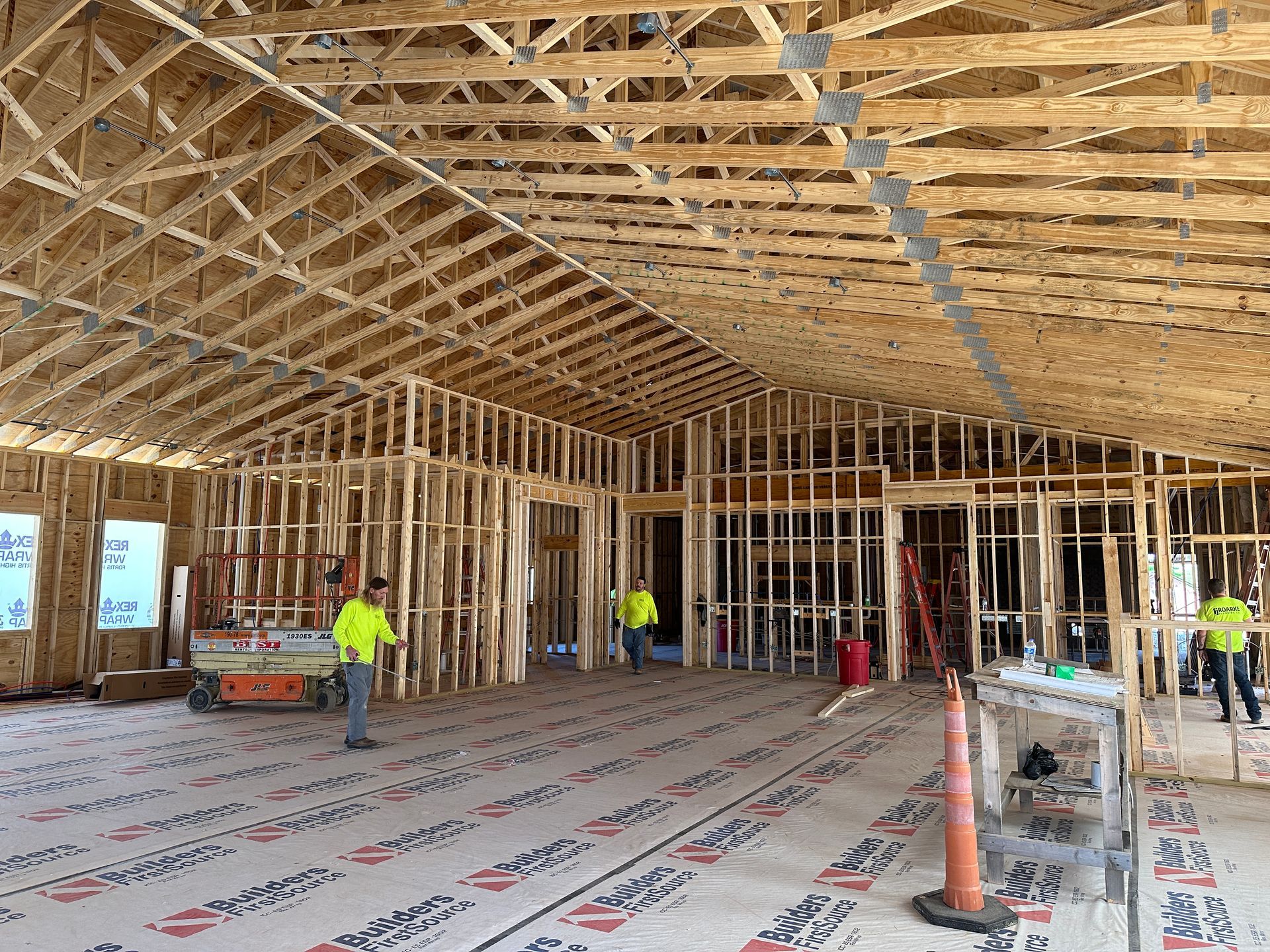A large room under construction with a lot of wooden beams.