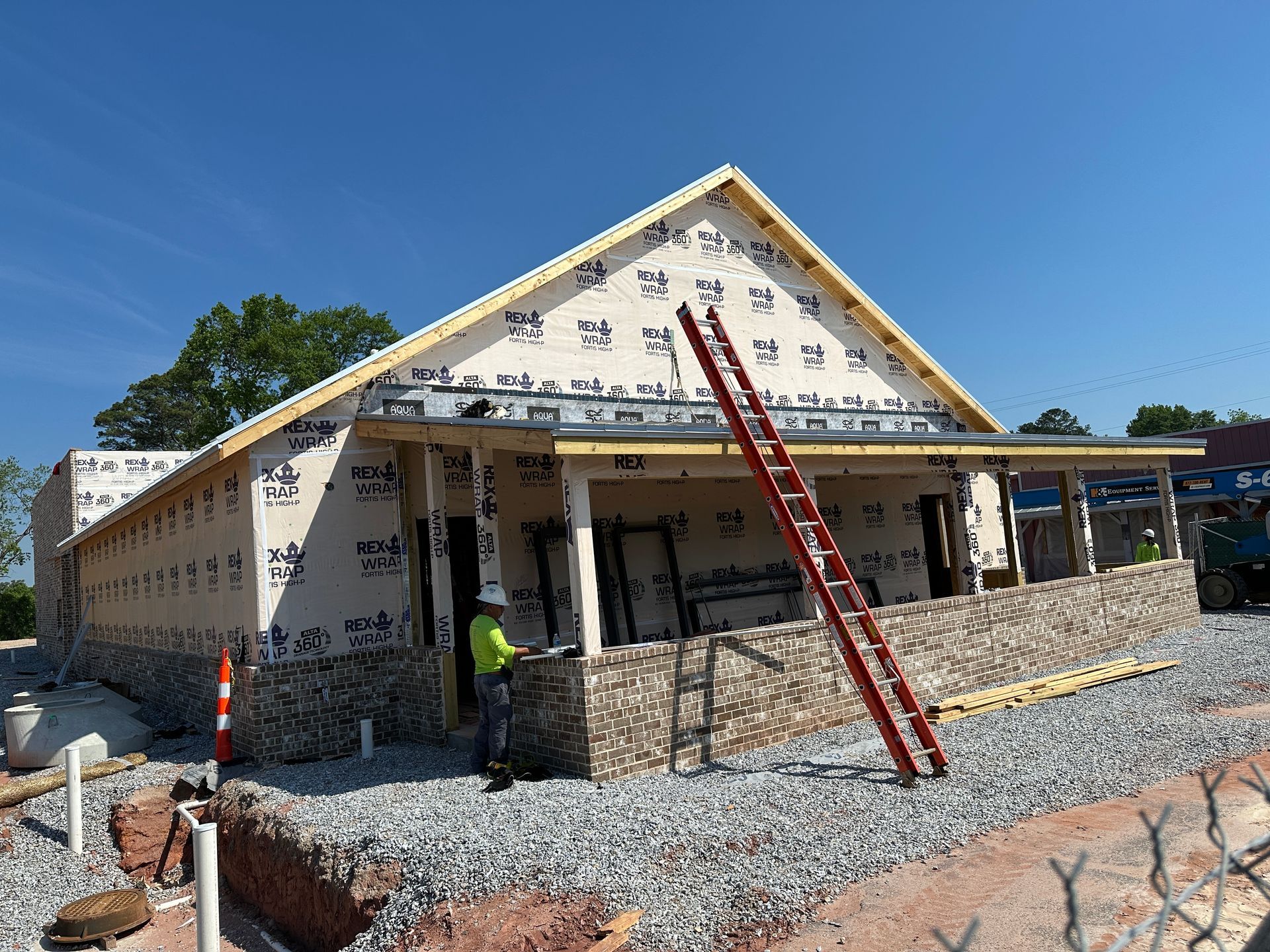 A ladder is sitting in front of a building under construction.