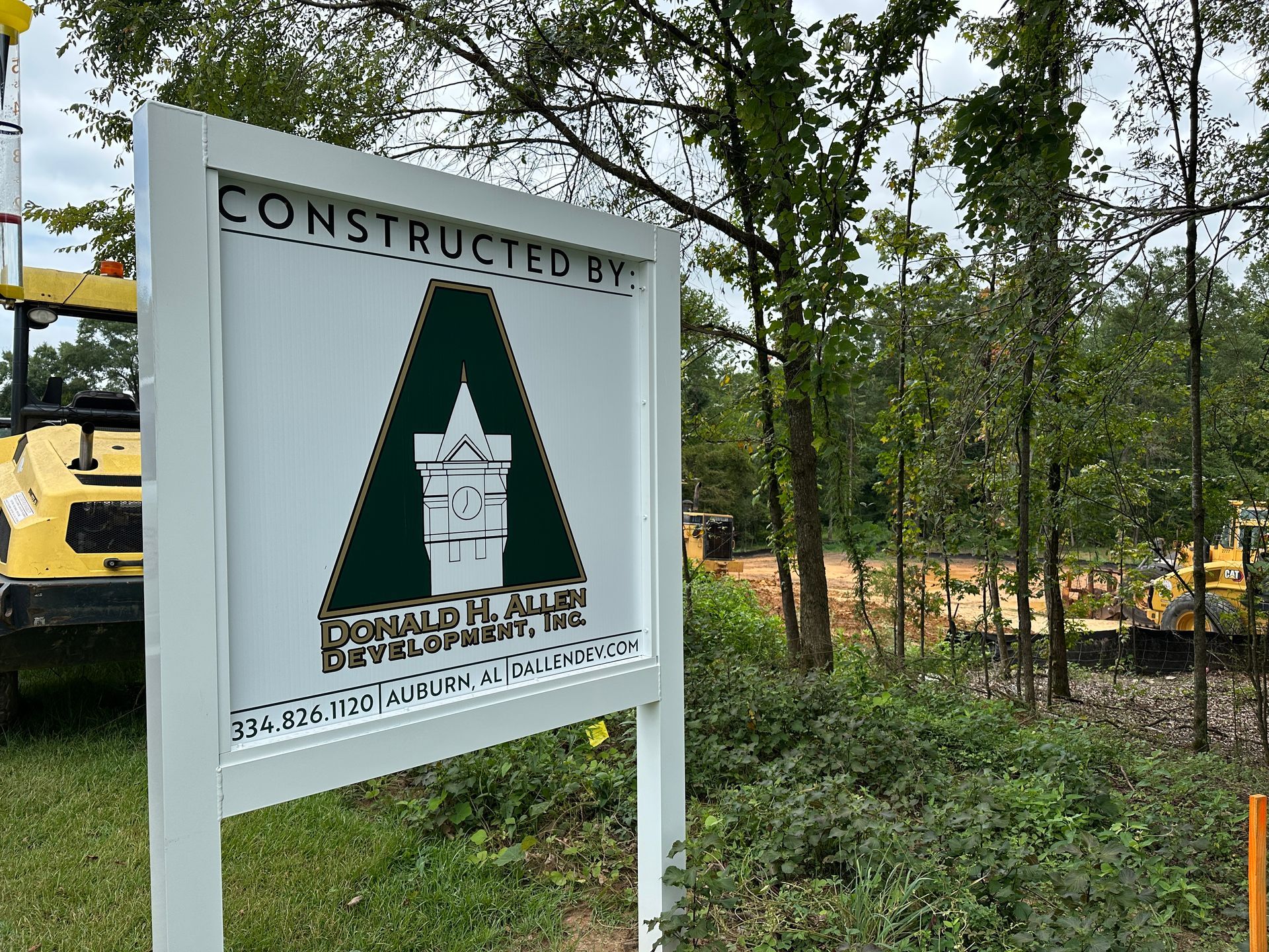 A construction site with a lot of gravel and trees in the background.