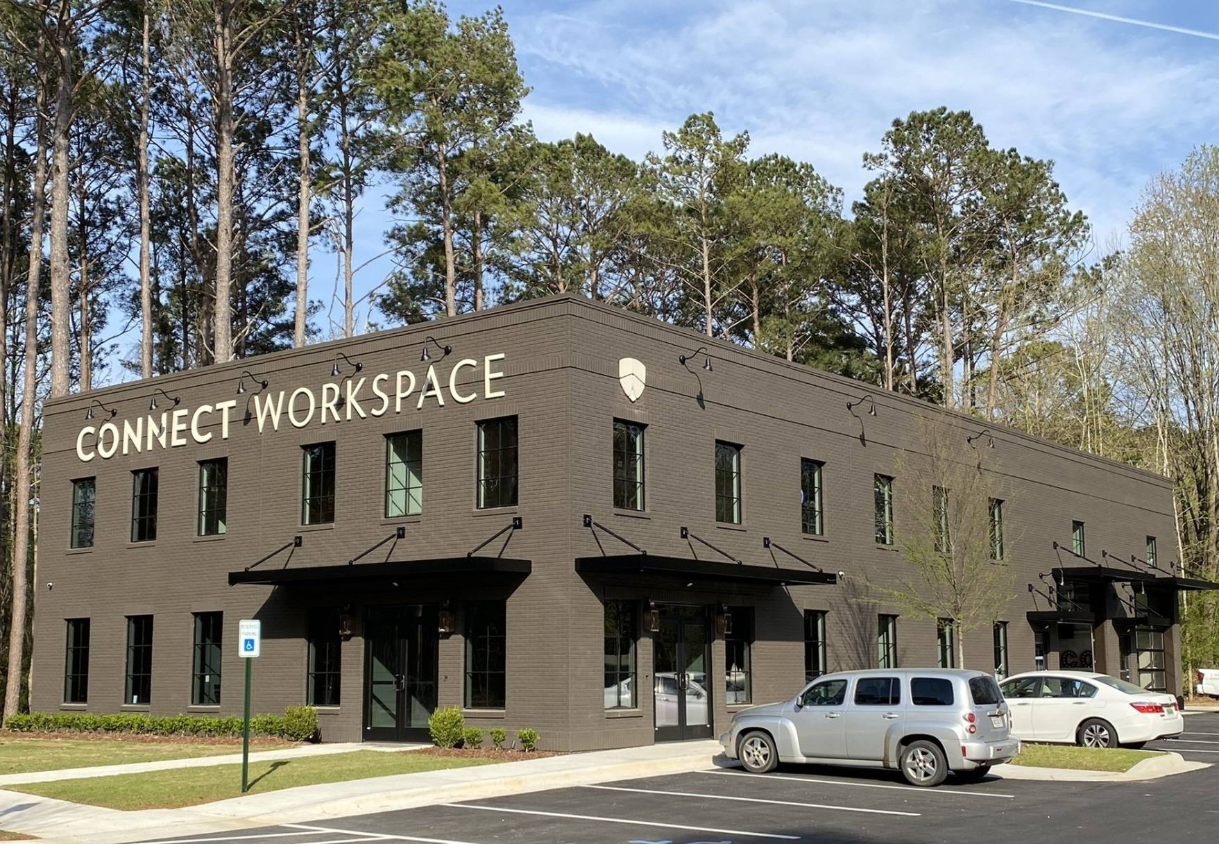 A connect workspace building with cars parked in front of it