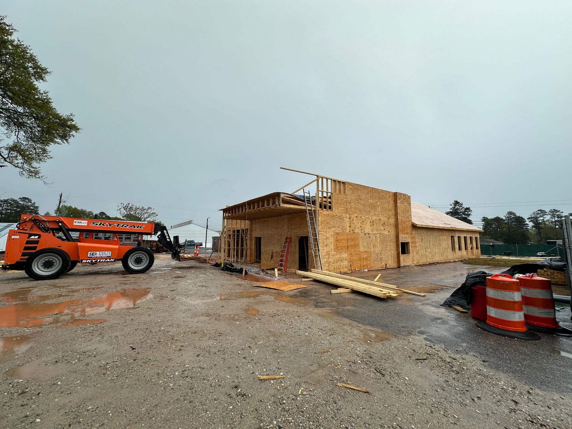 A construction site with a building under construction and a forklift.