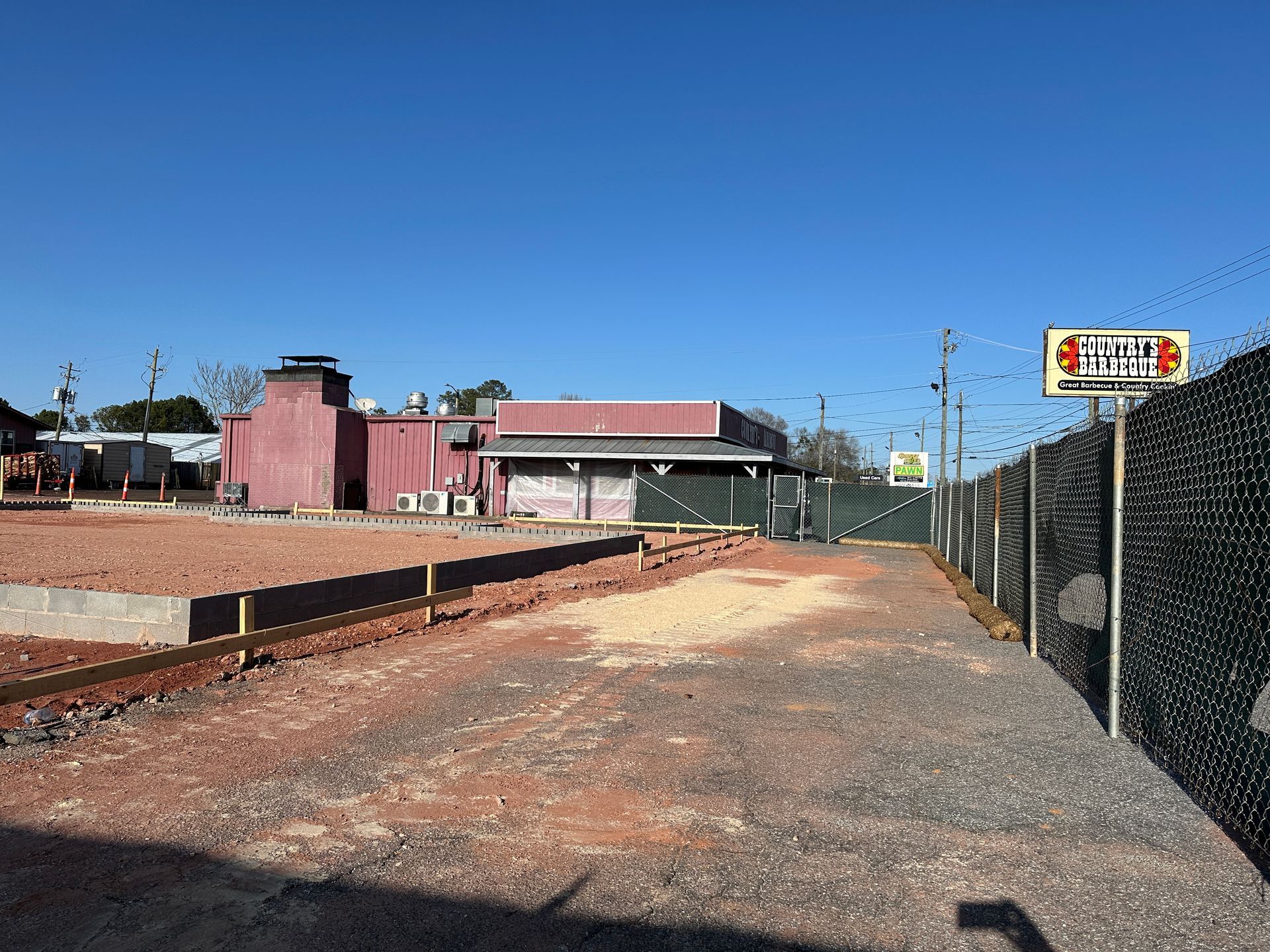 A fenced in area with a building in the background