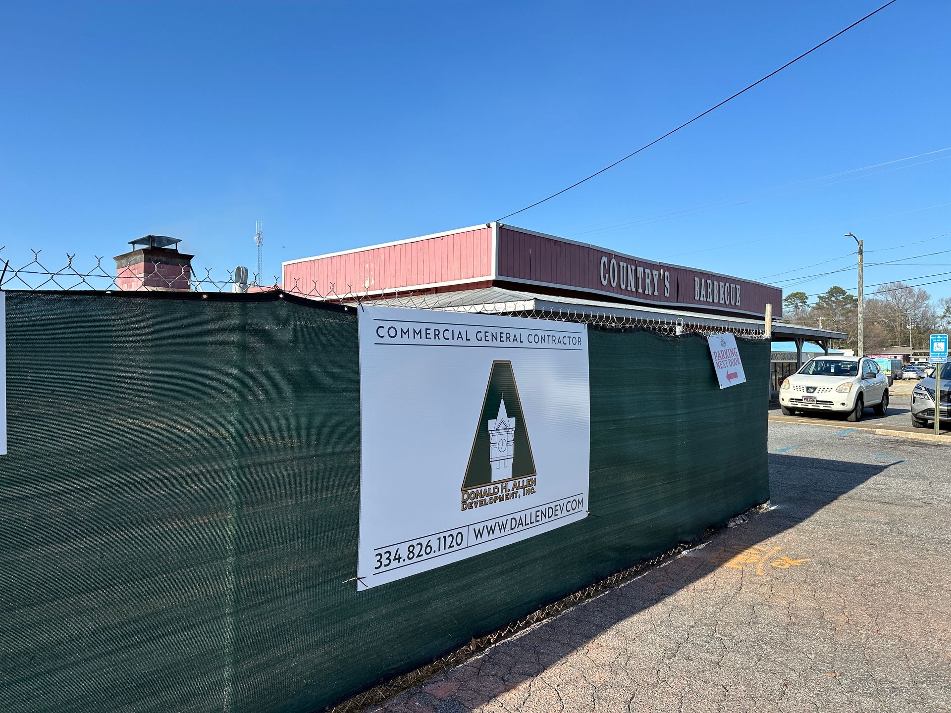 A green fence with a sign that says a on it