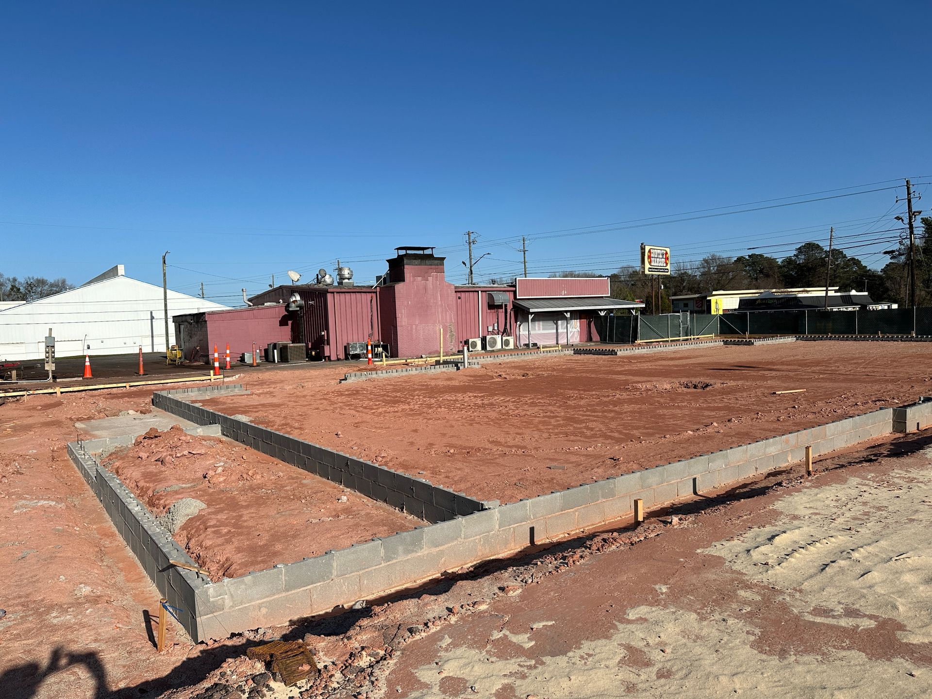A building is being built in the middle of a dirt field.