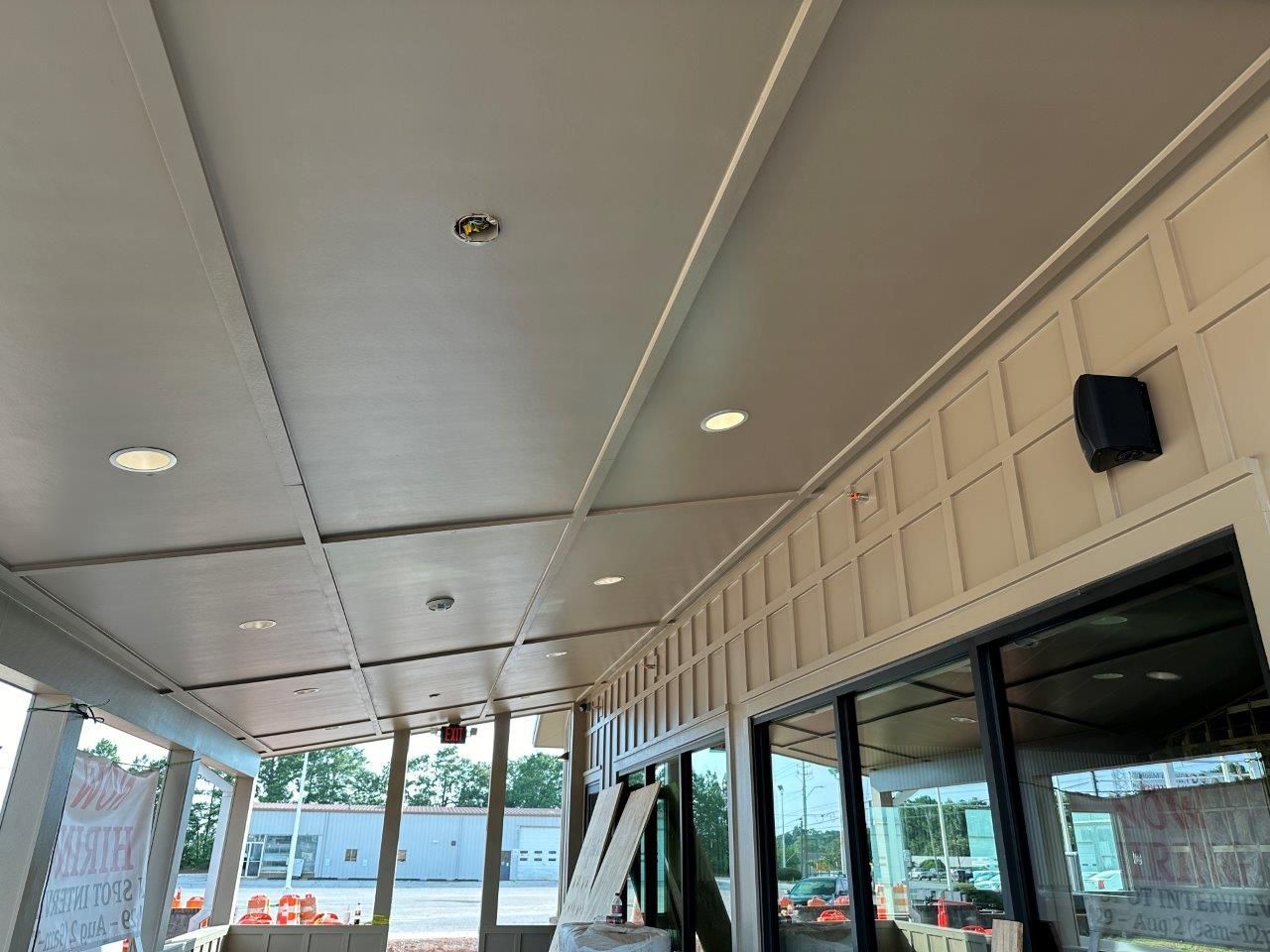 The ceiling of a building with a lot of windows.