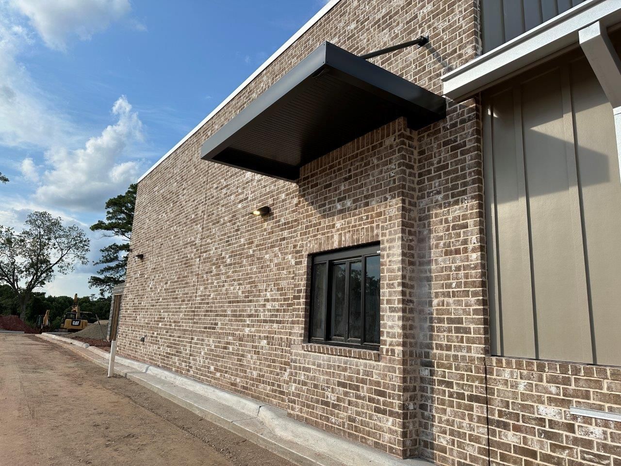 A brick building with a window and a canopy on the side.