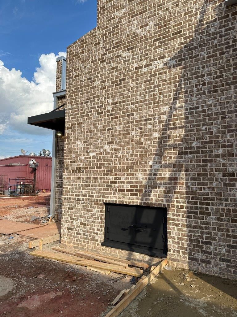 A brick wall with a window in the middle of it