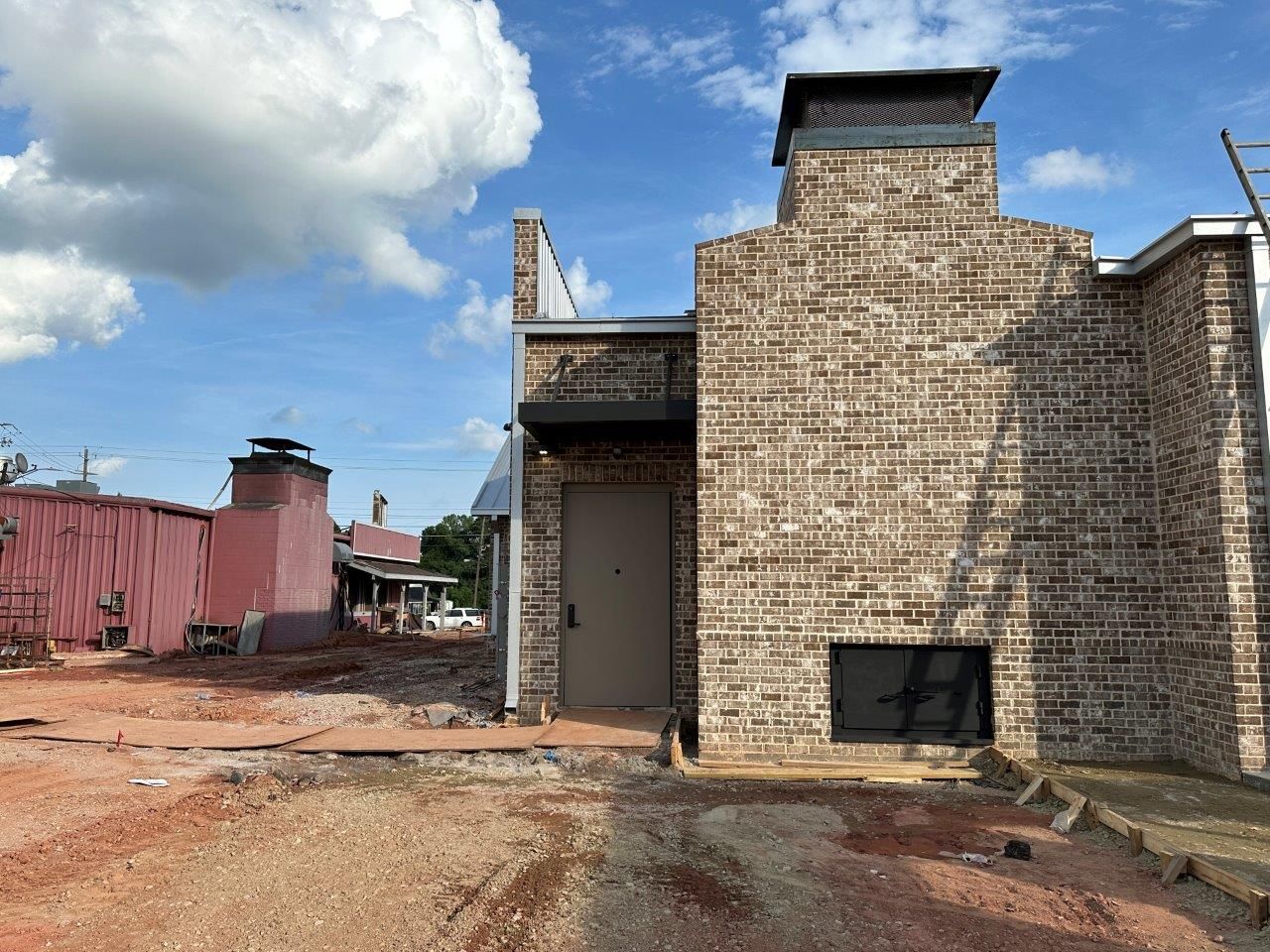 A brick building with a chimney on the side of it is being built.