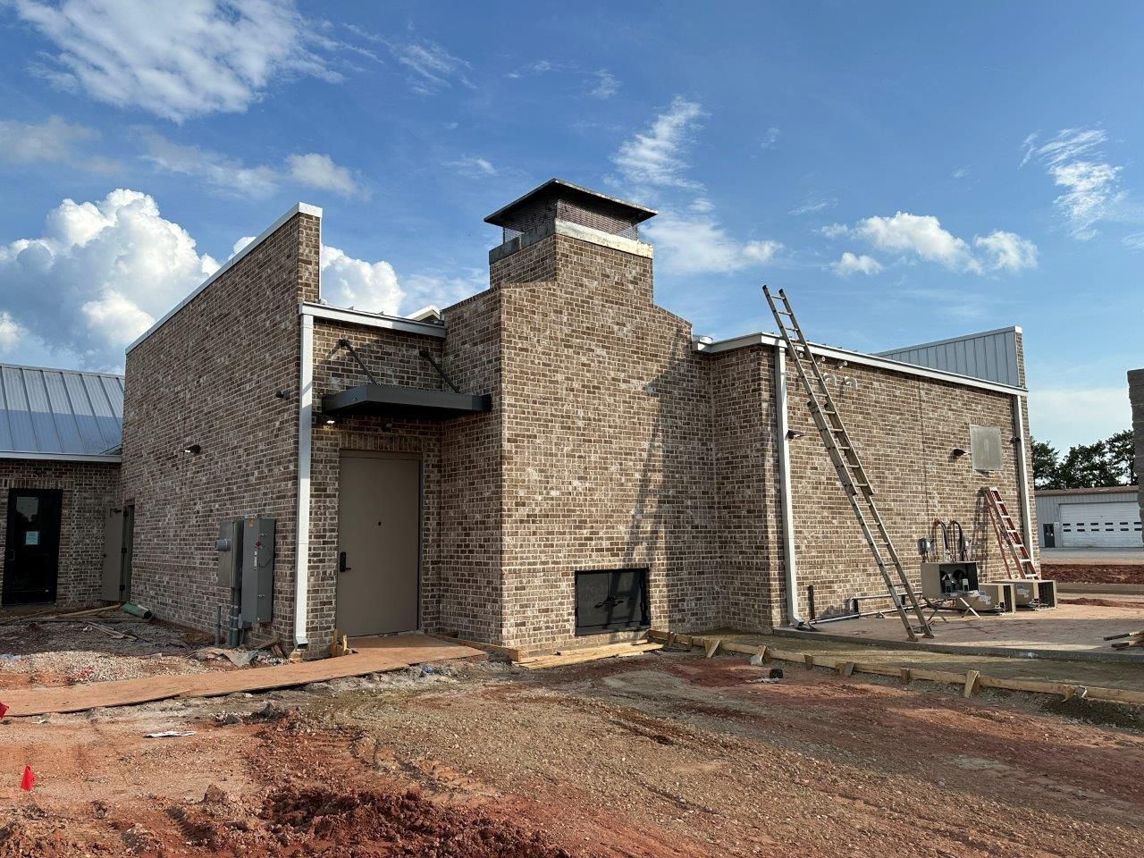 A brick building with a chimney on top of it is being built.