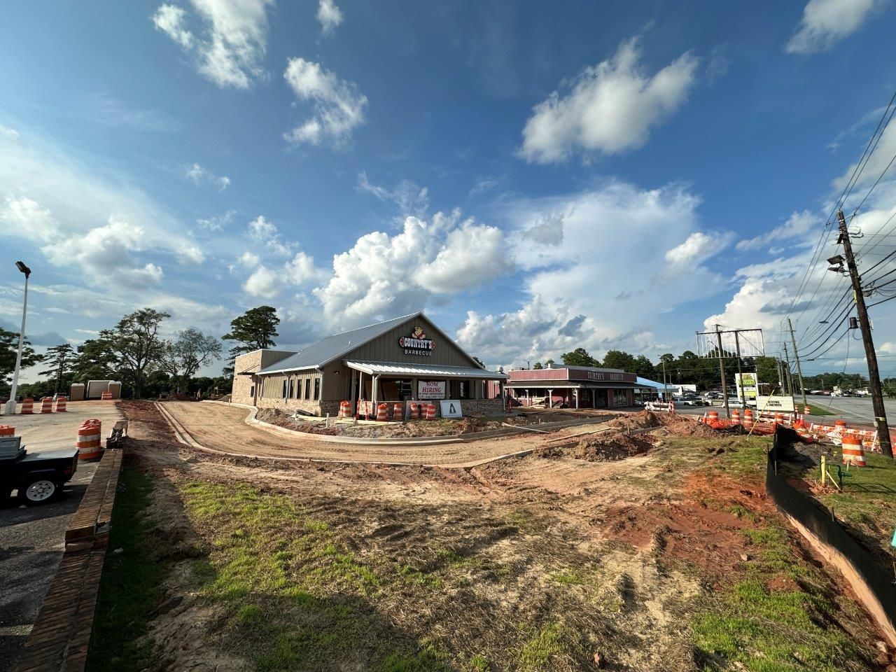 A large building is being built in the middle of a dirt field.
