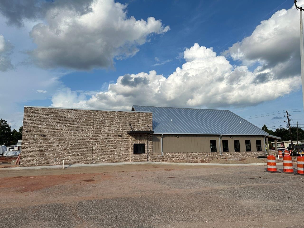 A brick building with a metal roof is under construction