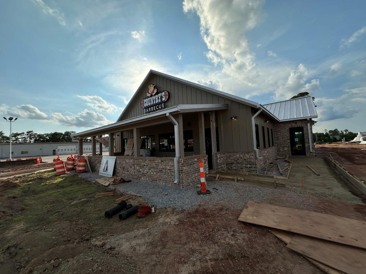 A large building with a porch and a sign on it is being built.