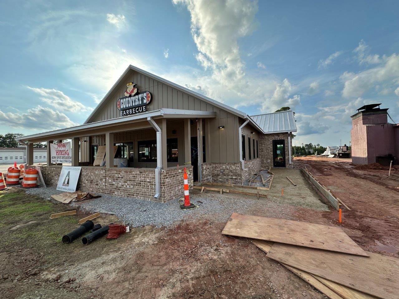 A building is being built in the middle of a dirt field.