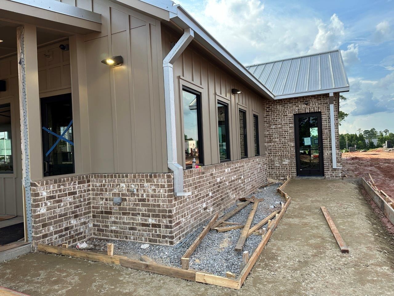 A brick building with a metal roof is being built.