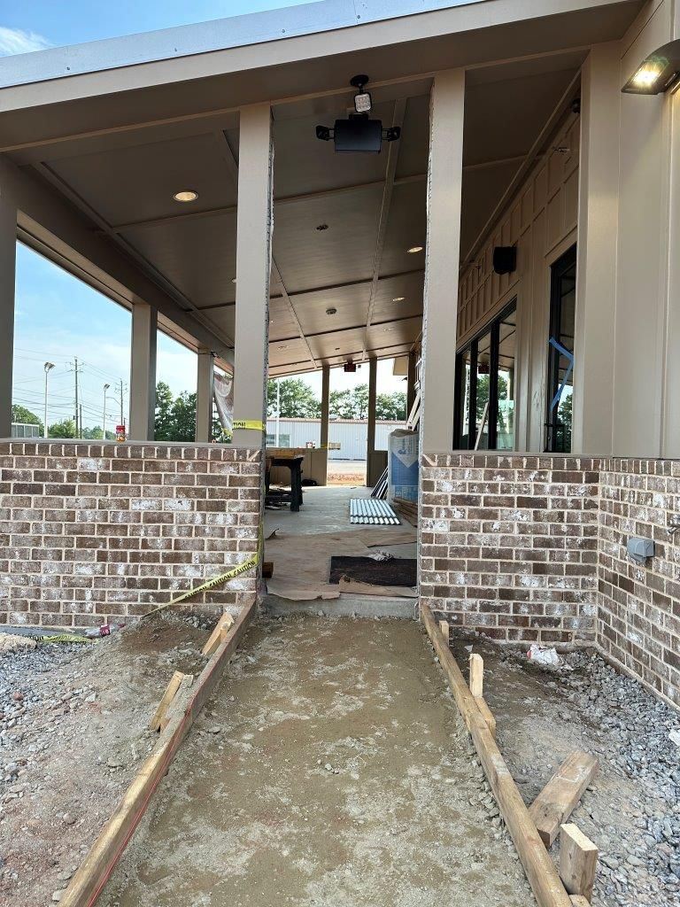A brick walkway leading to a building under construction.