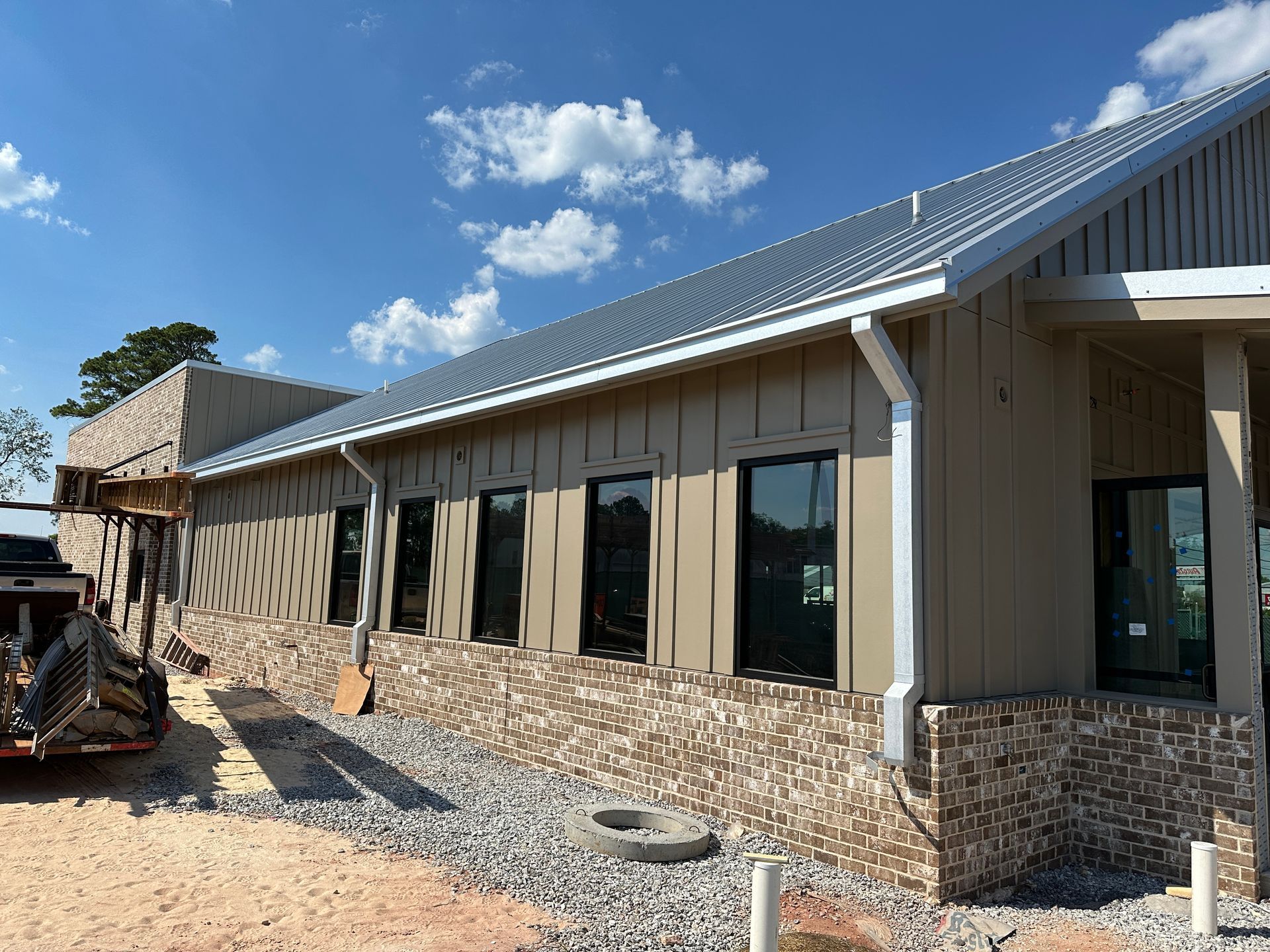 A building under construction with a lot of windows and a metal roof.