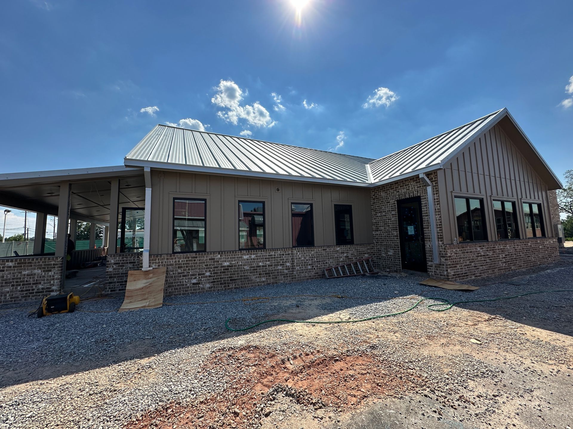 A large house with a metal roof and a lot of windows is being built.