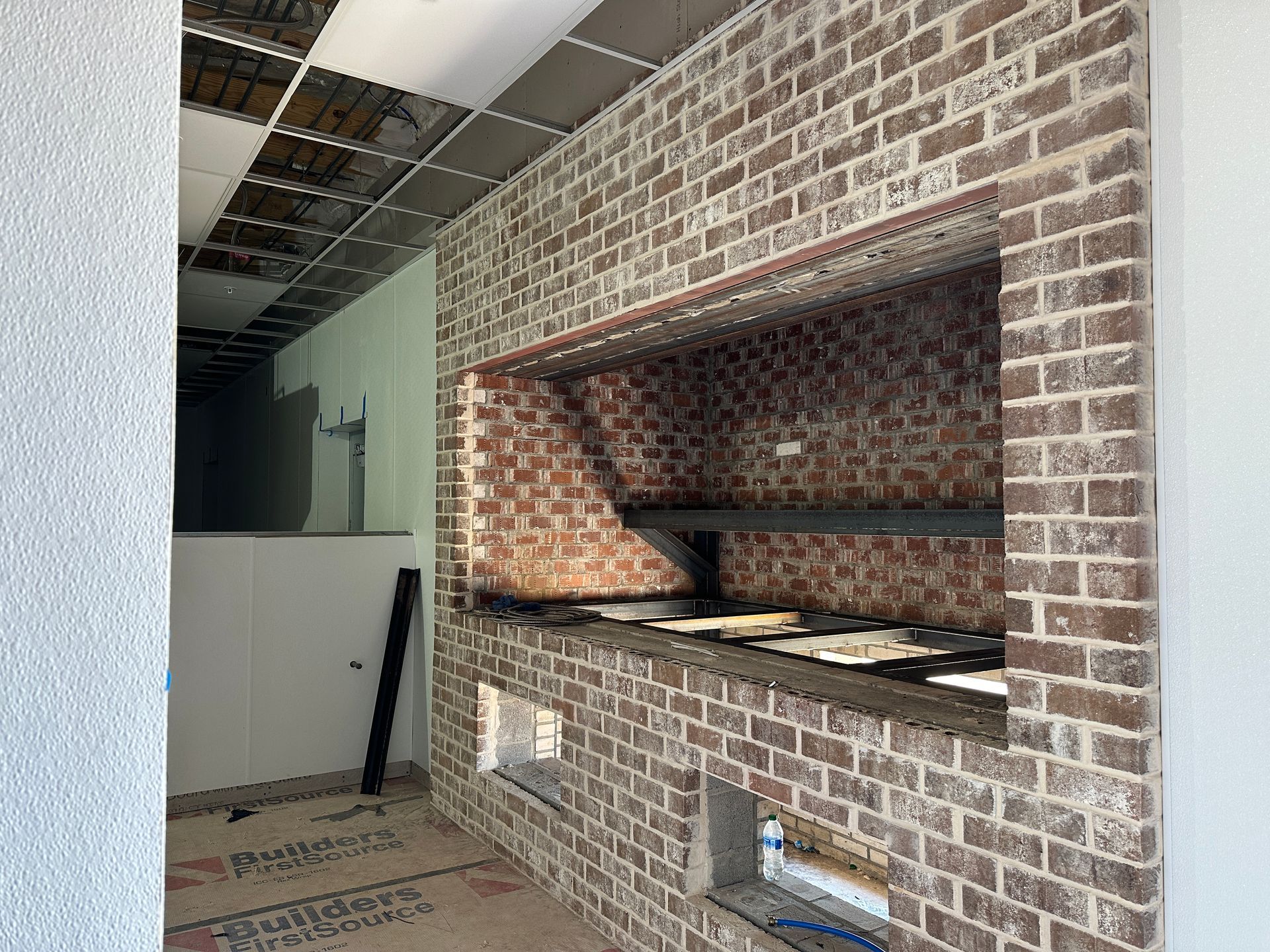 A brick wall with a window in the middle of it.