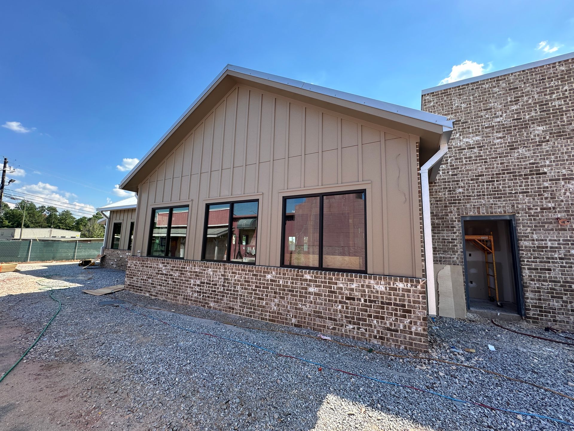 A large building with a lot of windows is sitting on top of a gravel lot.