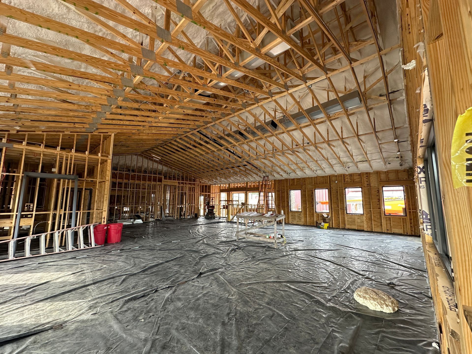 A large room under construction with a lot of wooden beams.