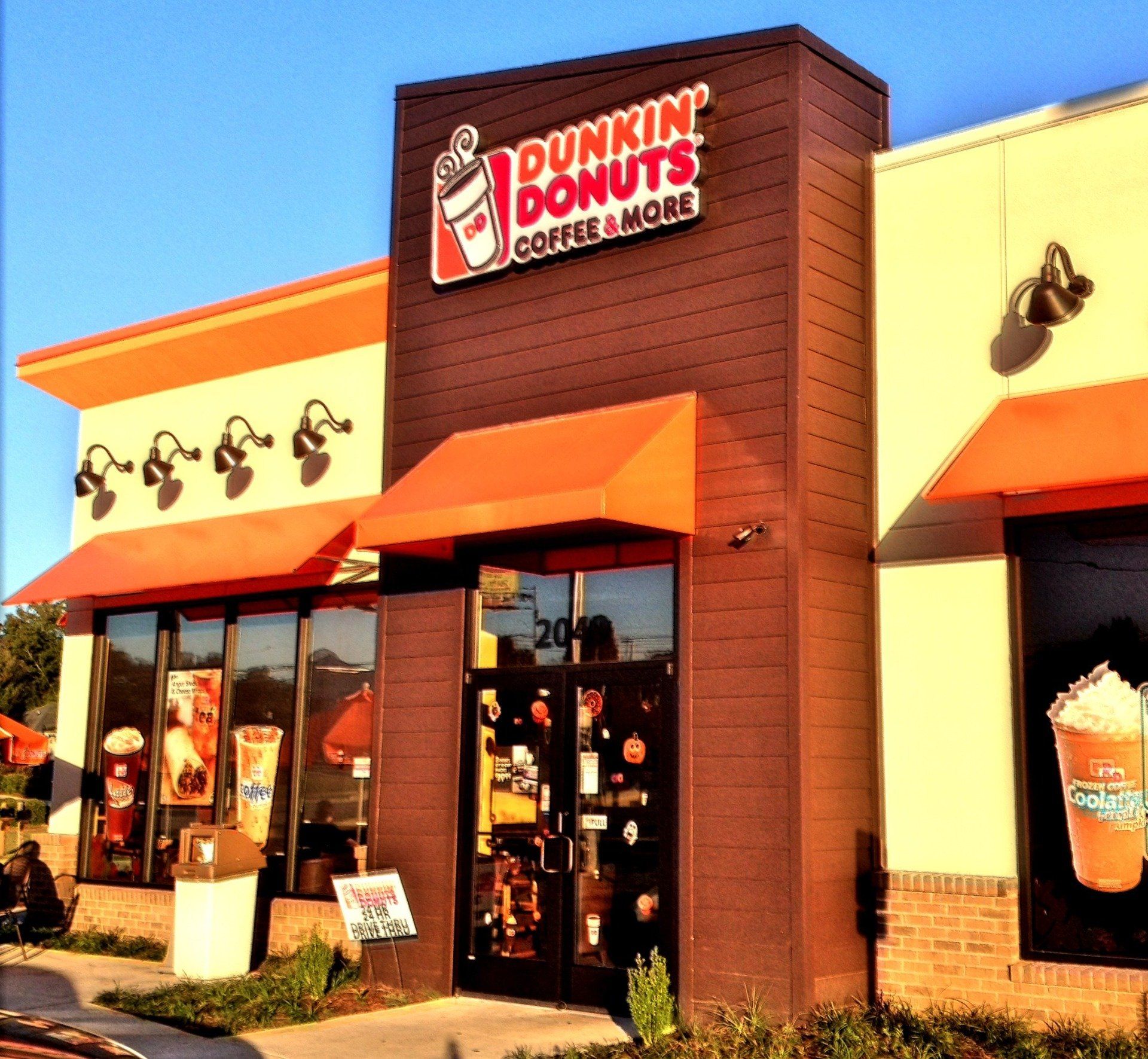 A dunkin ' donuts store with an orange awning