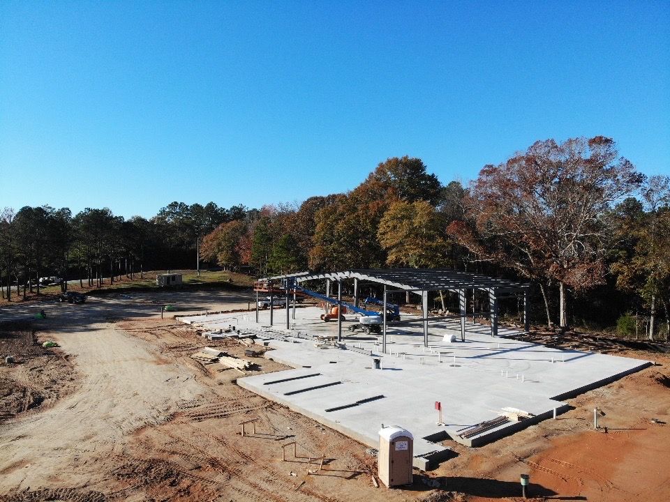 An aerial view of a construction site with trees in the background