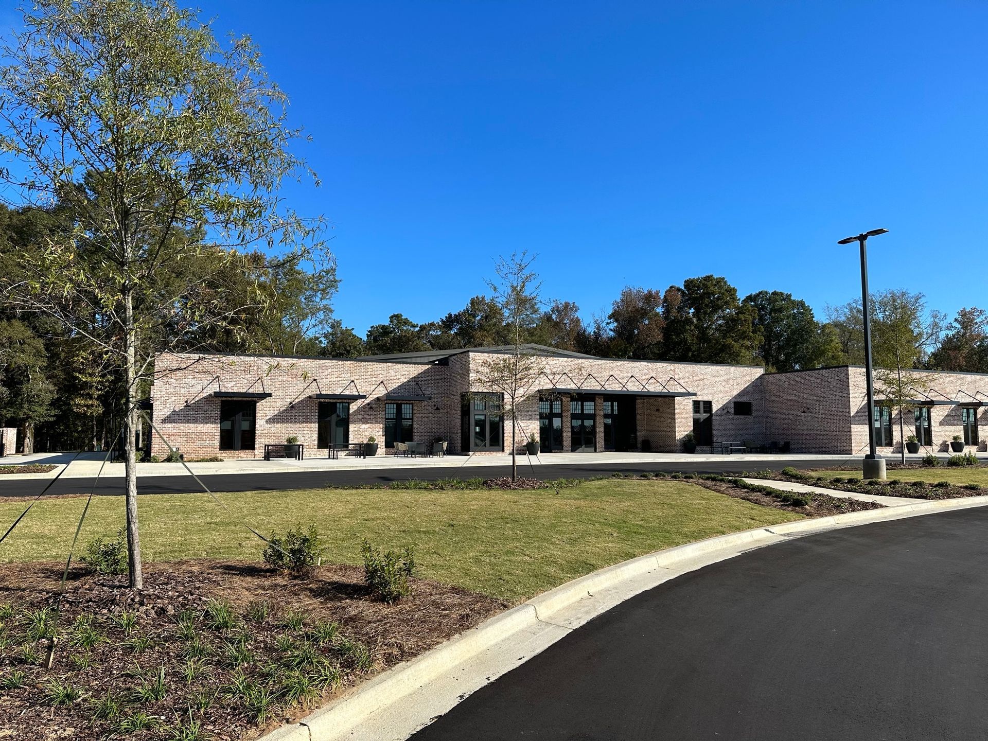 A large building with a lot of windows is sitting next to a road.