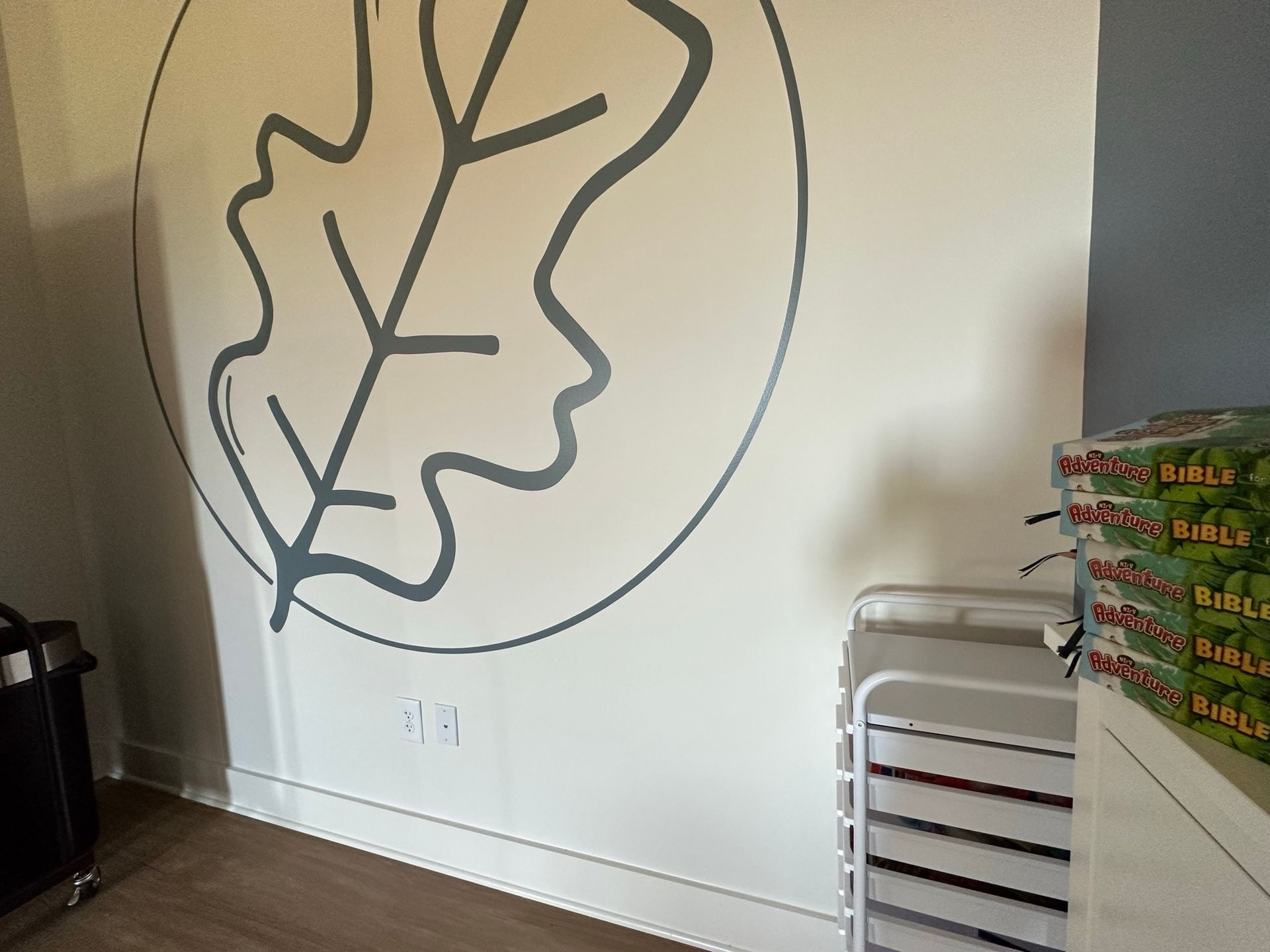 A white wall with a picture of an oak leaf on it