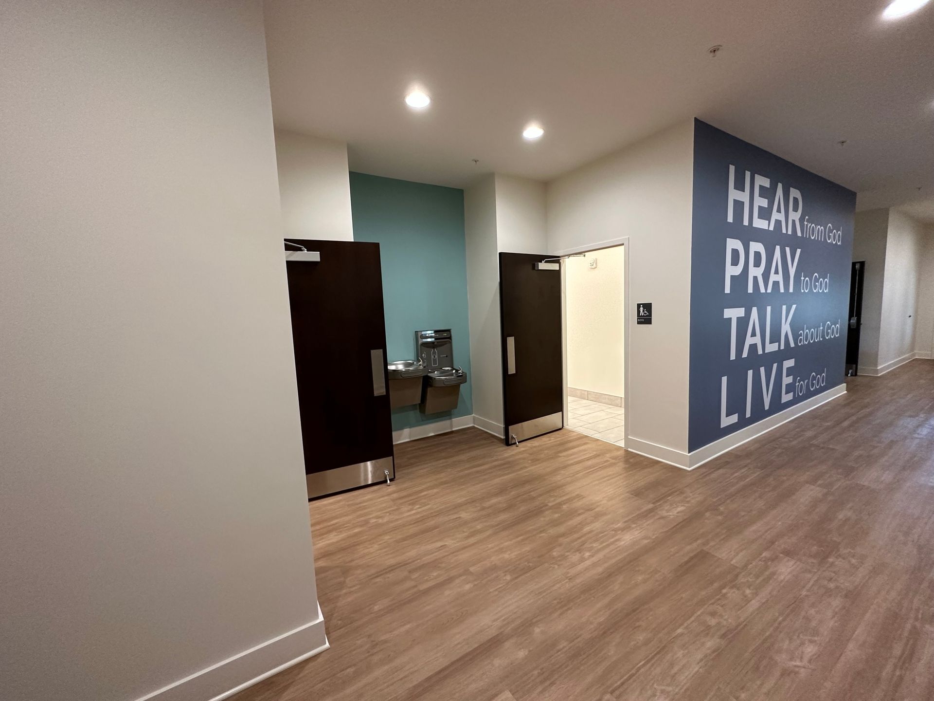 A hallway with a sign on the wall that says `` hear pray talk live ''.