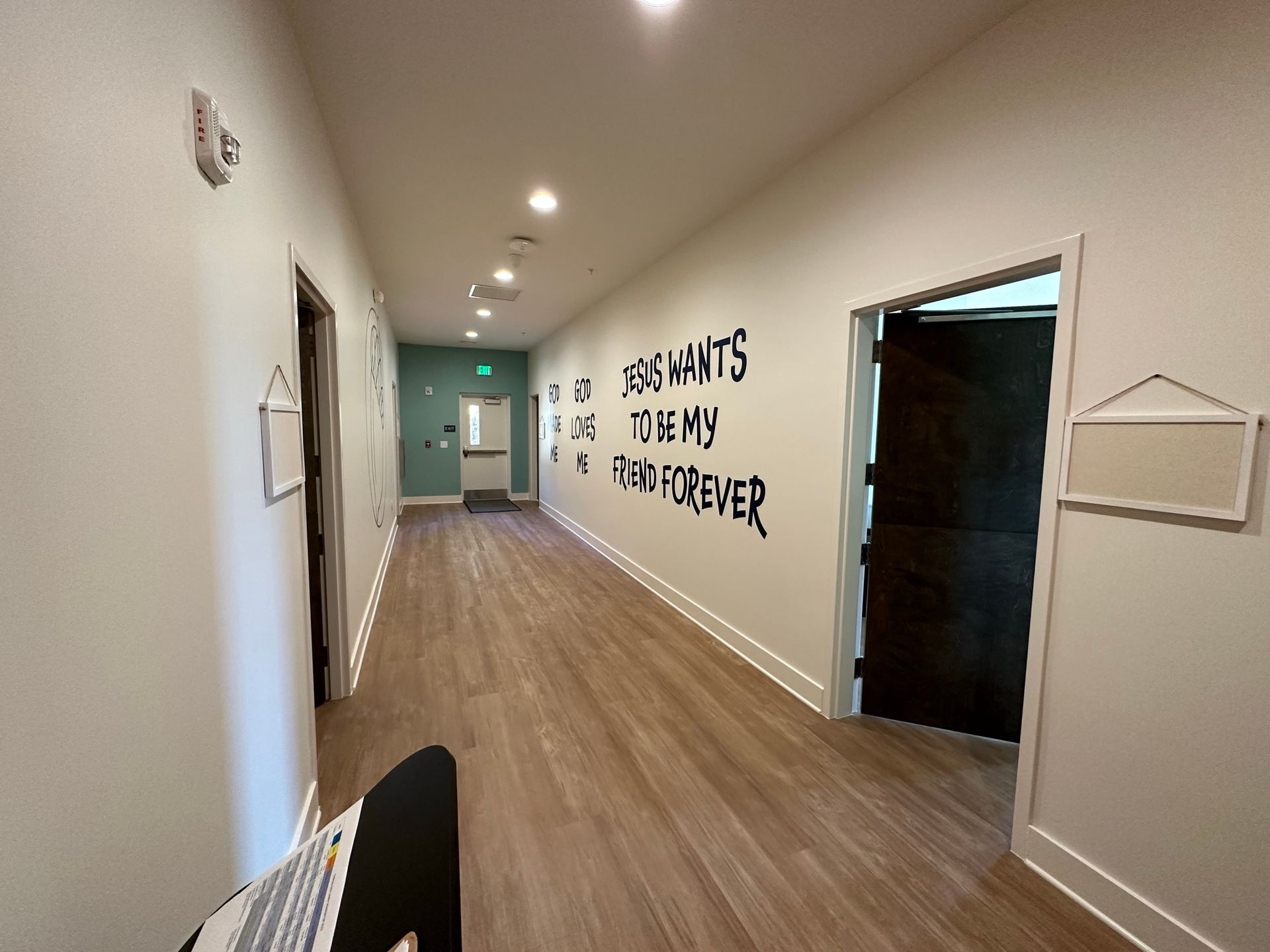 A long hallway with a sign on the wall that says `` she wants to be my wife forever ''