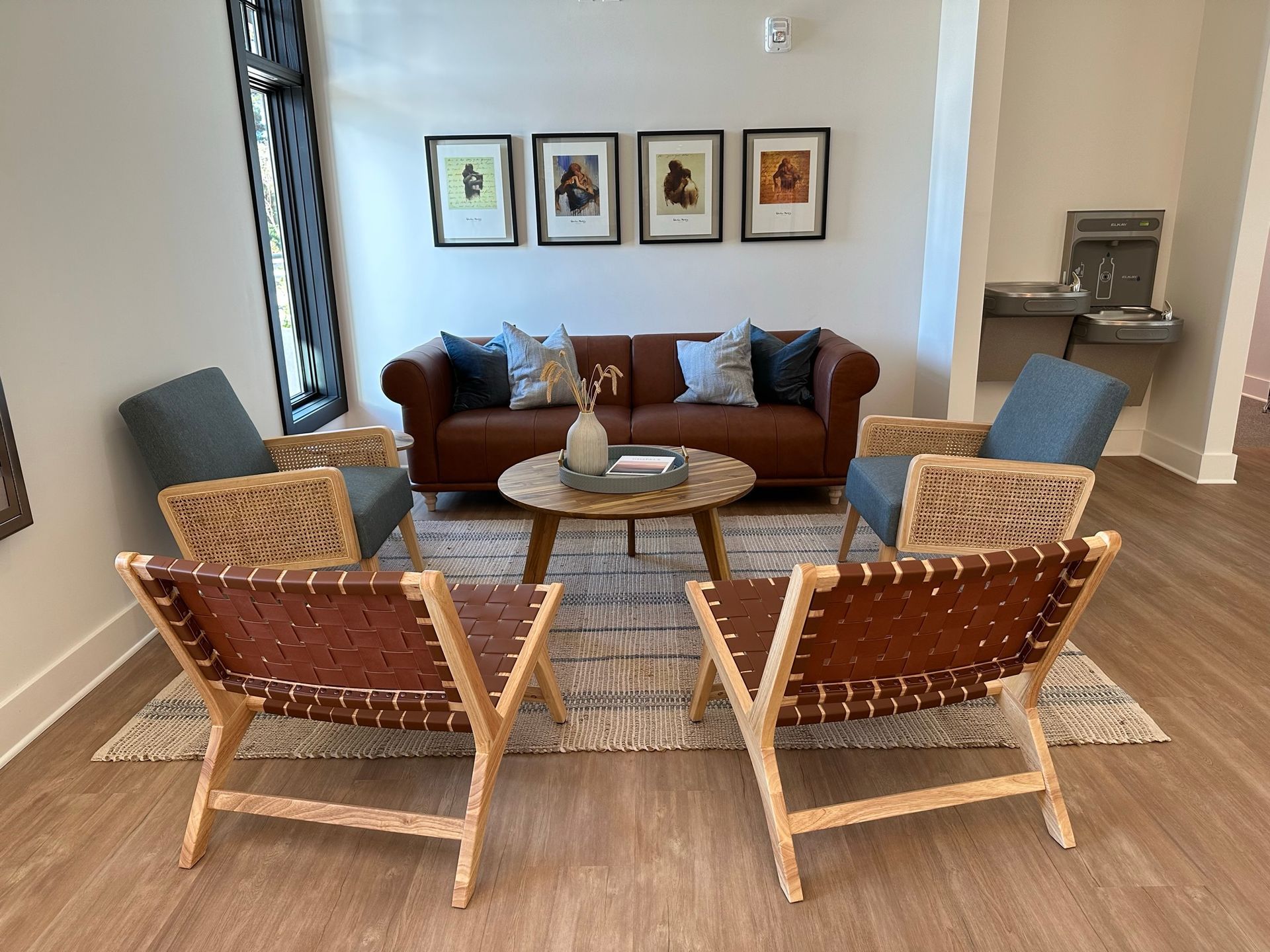A living room with a couch , chairs , and a table.