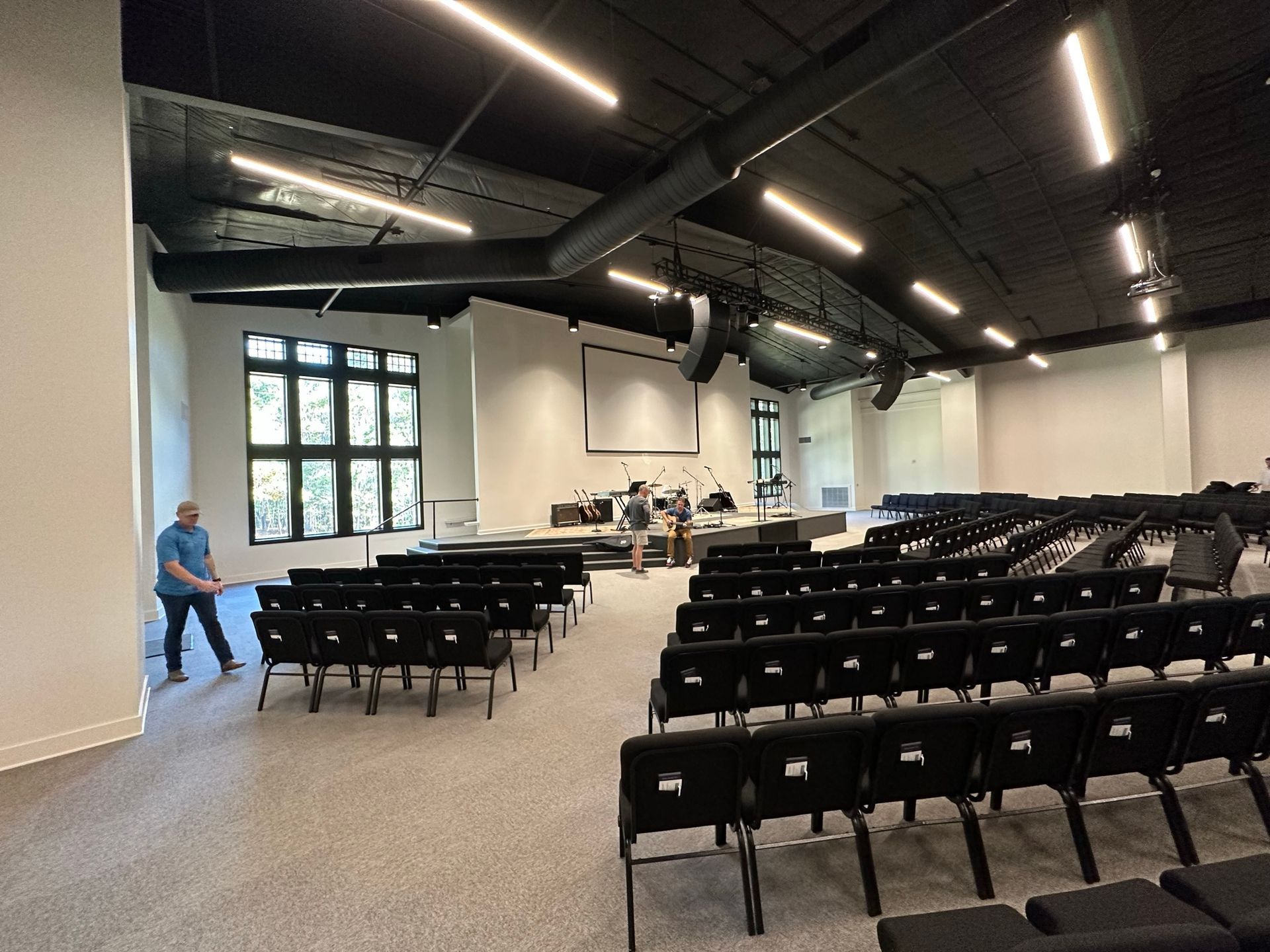 A large auditorium with rows of chairs and a projector screen.