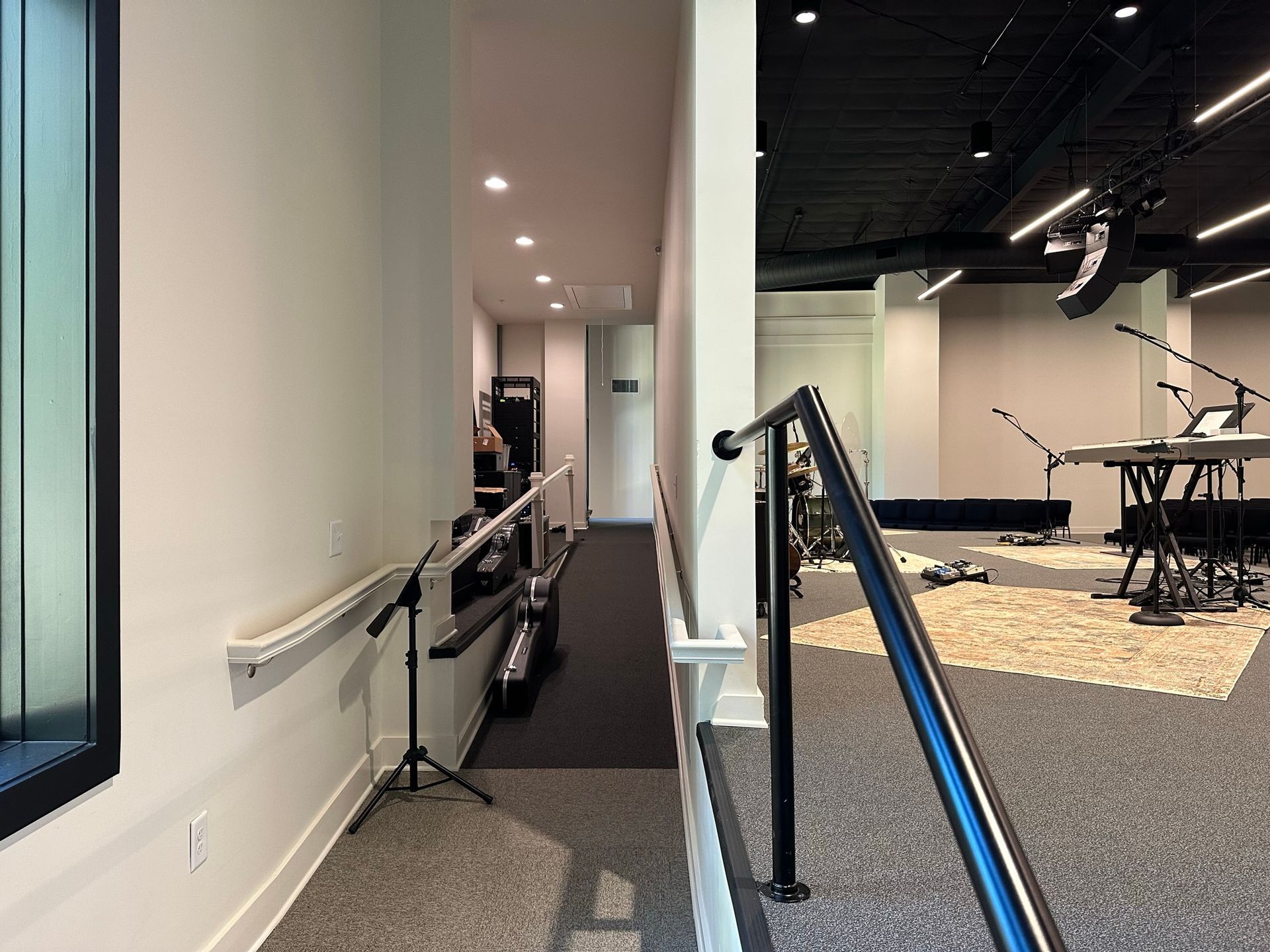 A hallway in a music studio with stairs leading up to a stage.