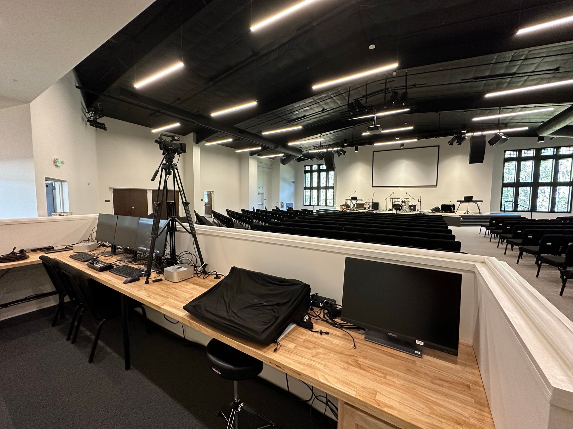 A large room with a wooden desk and computer monitors.