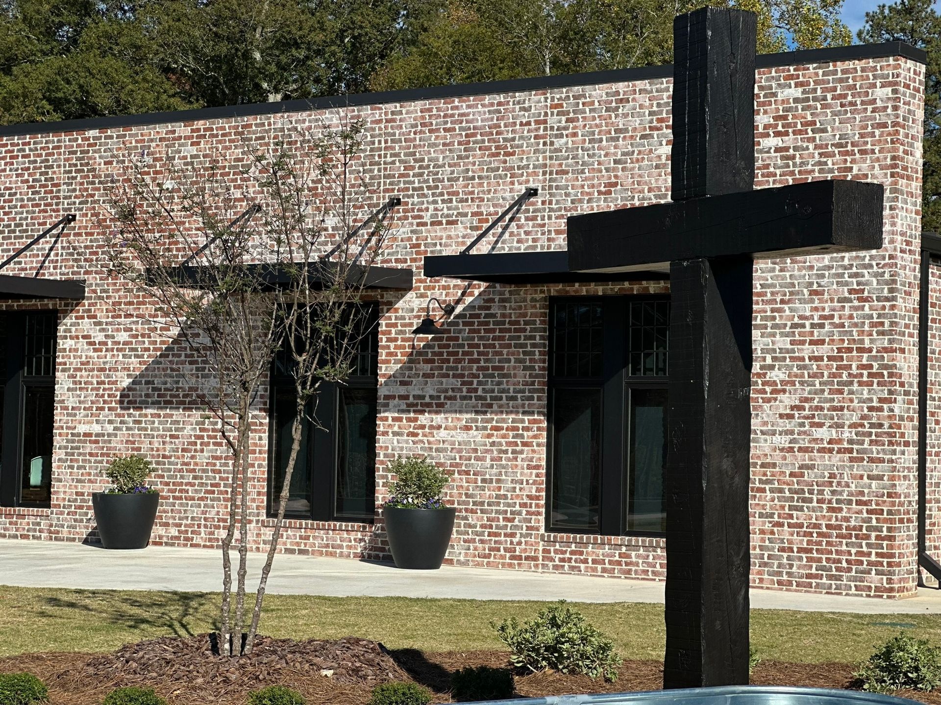 A brick building with a black cross in front of it