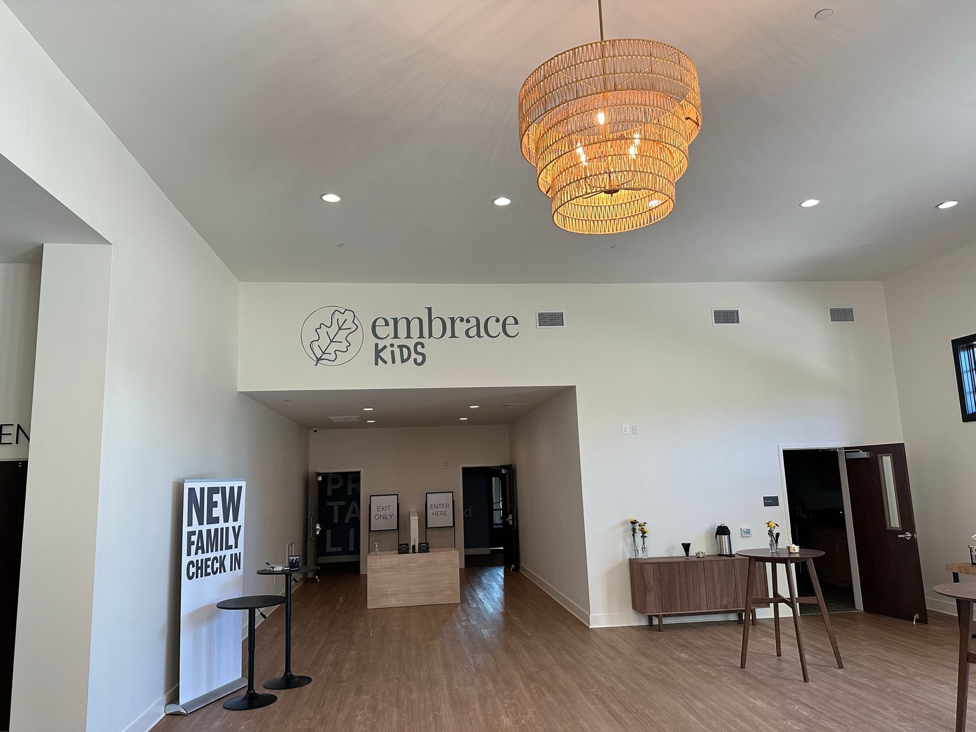 A large room with a chandelier and a sign that says embrace kids