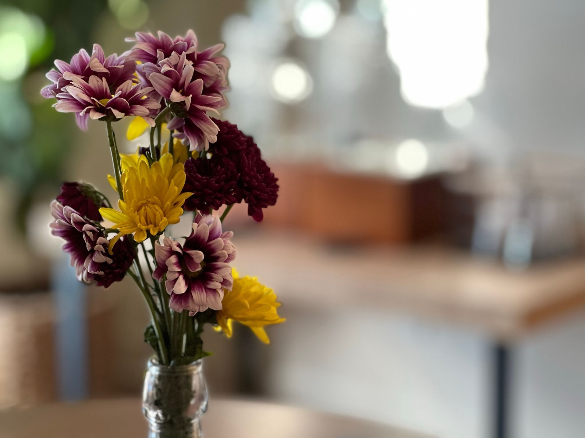 A vase filled with purple and yellow flowers on a table