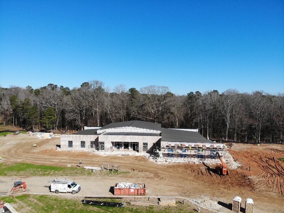 An aerial view of a building under construction in the middle of a field.