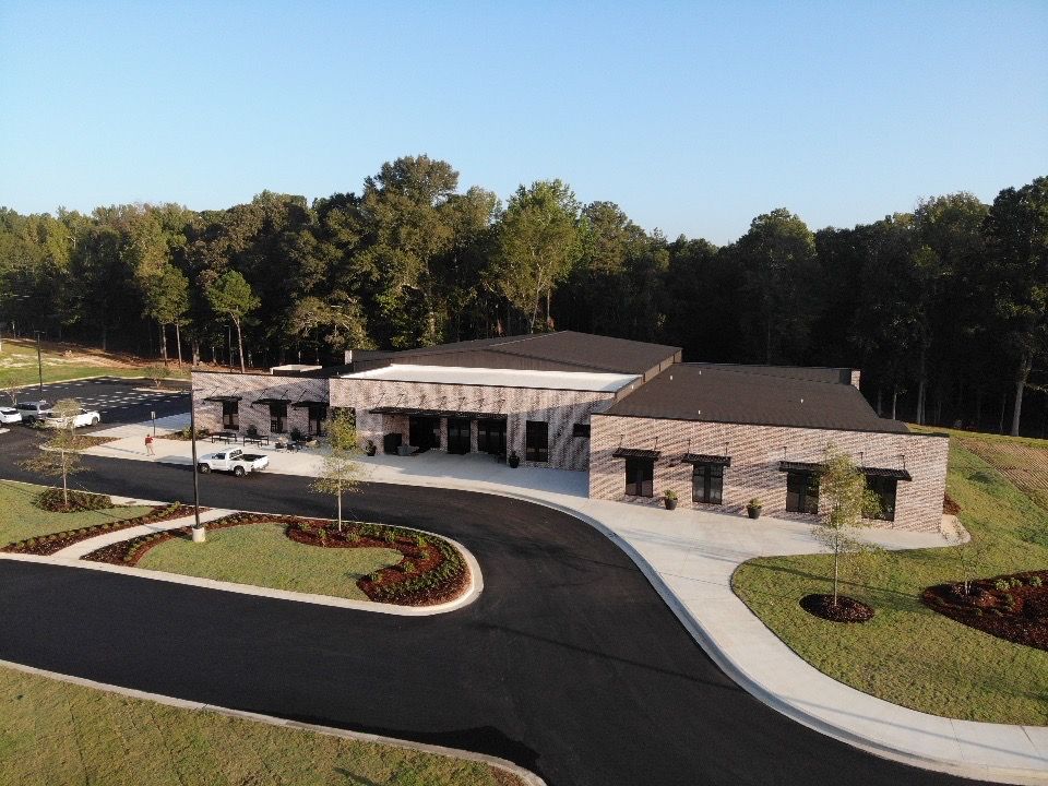 An aerial view of a large building with trees in the background
